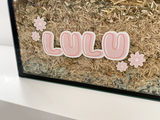 Pink static cling name sticker by Furnishables stuck to the front of a glass pet enclosure